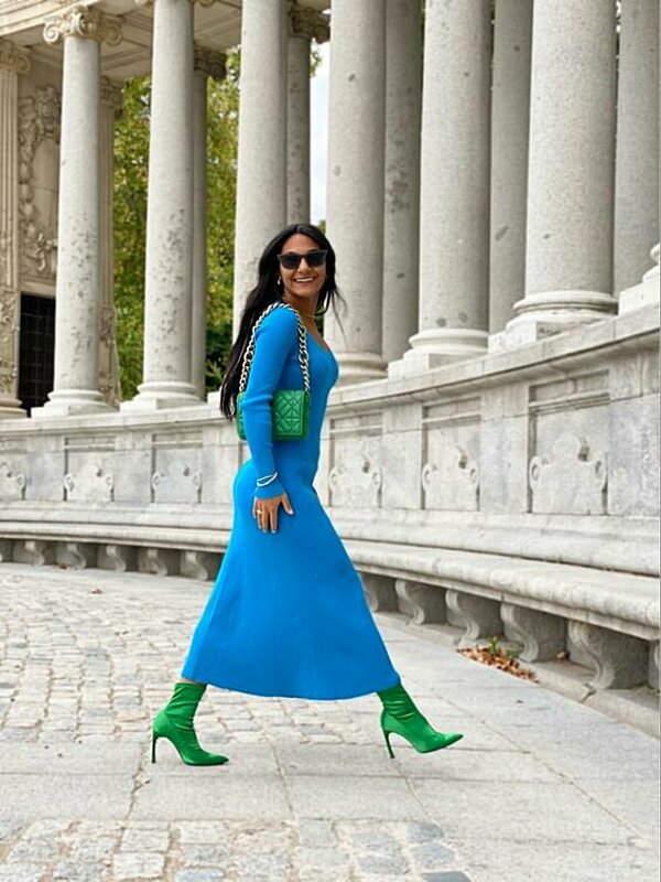 امرأة ترتدي فستانًا أزرق وحذاءًا أخضر اللون.