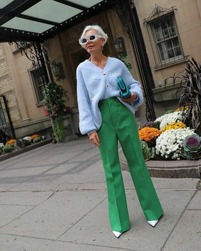 A woman wearing green pants and a blue sweater.