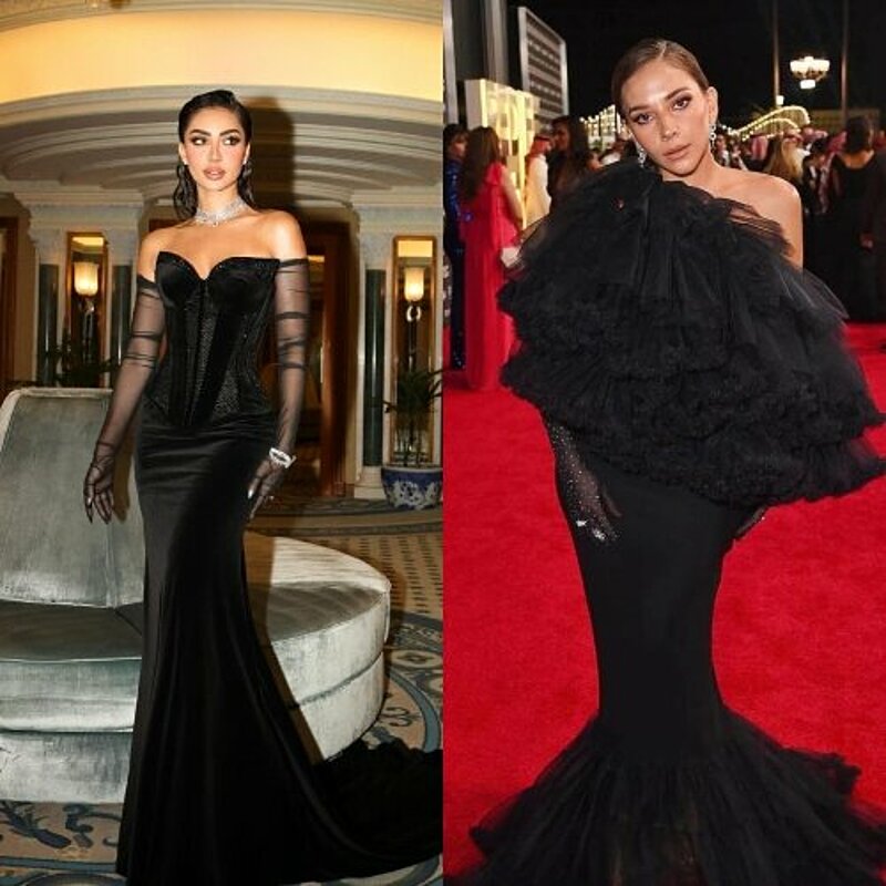 Two women in elegant black gowns posing at the Golden Globes, radiating grace and sophistication.
