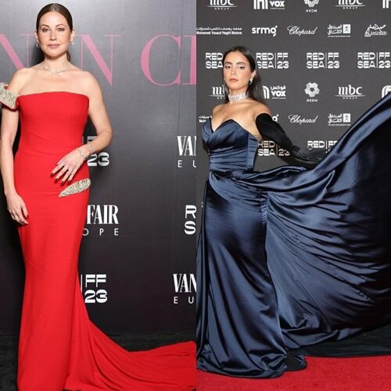 Two women in elegant red and blue gowns posing at the amfAR gala, radiating grace and sophistication.